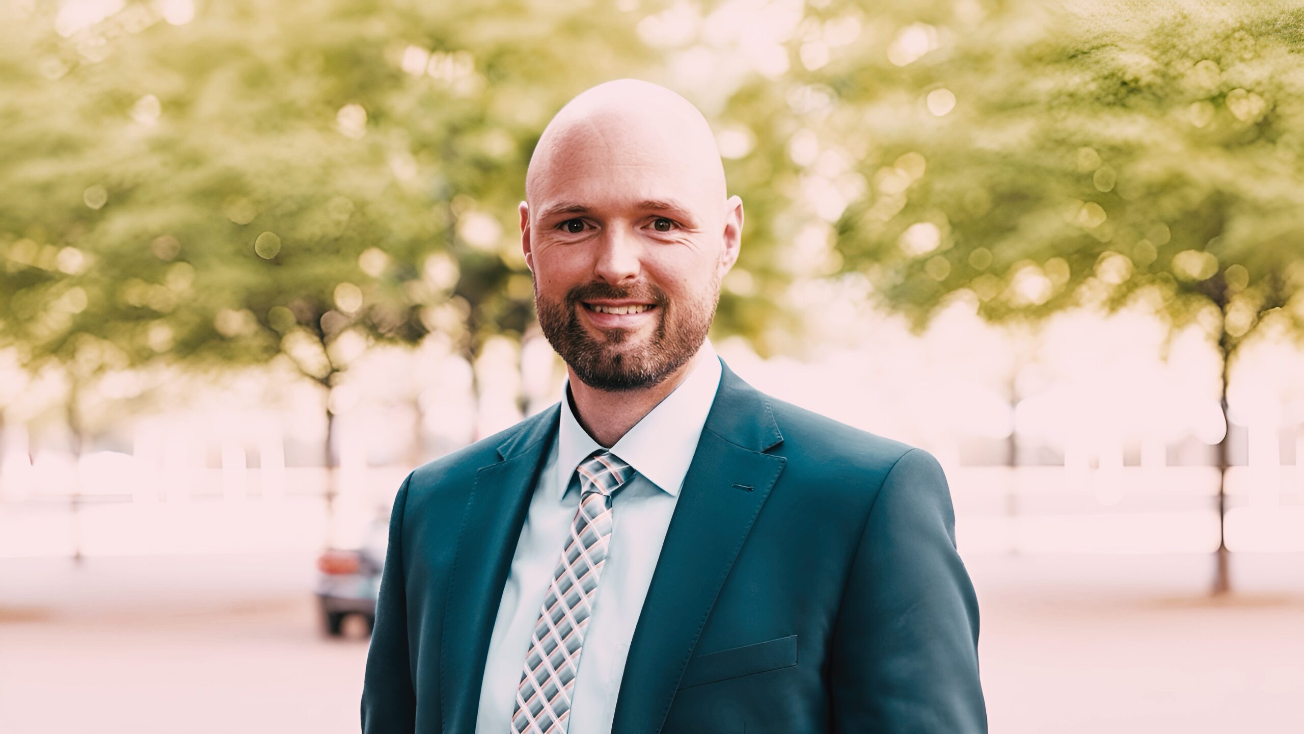 Alexander Hofmann, erfahrener Immobilienmakler aus Hannover, lächelnd in Businesskleidung vor Bürogebäude